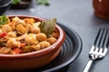 Close up. Ropa vieja, typical Canarian dish of chickpeas stew on earthenware casserole on dark base Royalty Free Stock Photo