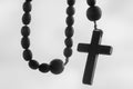 Close up rosary beads against white background. Selactive focus on cross. Christianity, religion, faith concept Royalty Free Stock Photo