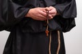 Close up of rosary and cross in monk hands on white background. Royalty Free Stock Photo
