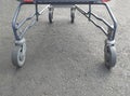 Close-up of rotating feed cart wheels. Metallic gray supermarket trolley with four rubber wheels