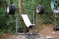 Close-up of a rough home-made simulator from old tires among thick trees in a city park, healthy lifestyle concept, selective