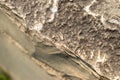 Close-up of rough, jagged rock surface with brown, gray, white and red colors - bottom left corner blurred