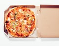 Close-up round baked pizza in open cardboard box