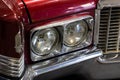 Close-up of the round headlamps of a red american classic car. Royalty Free Stock Photo