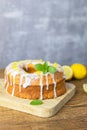 Close-up of a round lemon pie on a cutting board, decorated with frosting. Delicious citrus dessert. Vertical photo Royalty Free Stock Photo