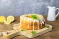 Close-up of a round lemon pie on a cutting board, decorated with frosting. Delicious citrus dessert. Vertical photo Royalty Free Stock Photo