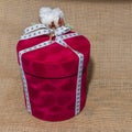 Close-up round red gift box with white bow and cotton flowers on a sackcloth background. Holiday concept Royalty Free Stock Photo