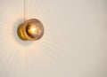 Small vintage crystal glass mounted wall lamp with refracting warm yellow light. Royalty Free Stock Photo