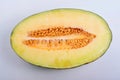 Close-up of a round yellow melon slice in half isolated in white background Royalty Free Stock Photo