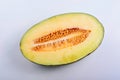 Close-up of a round yellow melon slice in half isolated in white background Royalty Free Stock Photo