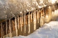 Close-up of a row of icicles frozen at a metal staircase at sunset