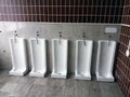 Close up row of outdoor urinals men public toilet Royalty Free Stock Photo