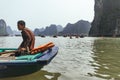 Close up rowing boats man sit in the boat that floating on emerald water with limestone islands in background in summer.