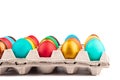 Close-up of rows of colored Easter eggs in a cardboard box.