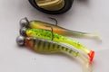 Close up of fishing lures on jig heads on a plain background