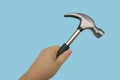 close-up of rubber-handled hammer with nail puller, round head for fine work in female hand, manual universal percussion tool for Royalty Free Stock Photo