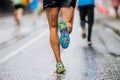 close-up runner athlete run marathon race on wet asphalt