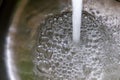 Running water out of a water tap in a metallic kitchen sink Royalty Free Stock Photo