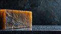 Close up of a rustic block of artisanal cheese with a textured rind against a dark background Royalty Free Stock Photo