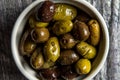 Close up of rustic bowl of mixed olives on wood