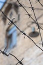 Close-up of a rusty barbed wire fence surrounding a concentration and extermination camp