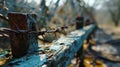 A close up of a rusty barbed wire fence with trees in the background, AI