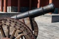 Rusty cannon on wooden wheeled cart.