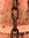 Close-up of a rusty chain in front of red rusty steel drum Royalty Free Stock Photo