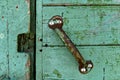 A close up of a rusty handle on old green wooden door Royalty Free Stock Photo