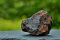 Close-up of a Rusty Iron Ore on a Blurred Green Background