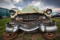 Close up on a rusty old classic car front, abandoned with broken parts in the junkyard Royalty Free Stock Photo