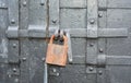 A close up on a rusty padlock on an old, antique black metal door as a symbol of mystery, privacy or secret Royalty Free Stock Photo
