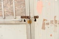 Close up of rusty steel door securely locked with a golden pad Royalty Free Stock Photo