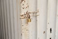Close up of rusty steel door securely locked with a golden pad Royalty Free Stock Photo