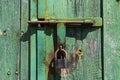 Old rusted grungy wooden garage door with latch and padlock. Royalty Free Stock Photo