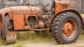 A close-up of a rusty vintage tractor in a village barn