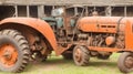 A close-up of a rusty vintage tractor in a village barn.