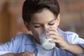 Close up 8s boy drinking tasty fresh milk, holding glass Royalty Free Stock Photo