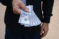 Close up of man handing over stack of 100 dollar bills. Royalty Free Stock Photo