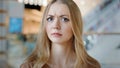 Close-up sad angry serious female face indoors portrait blond 20s girl millennial Caucasian woman lady confused female Royalty Free Stock Photo