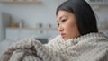 Close up sad depressed Asian chinese woman alone at home covered in blanket thoughtful japanese girl deep in thoughts Royalty Free Stock Photo