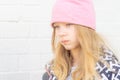 close-up of a sad girl against a white brick wall Royalty Free Stock Photo