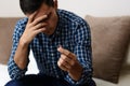 Divorce concept. Sad lonely man holding engagement ring sitting at home. Depression after a divorce. Selective focus. Royalty Free Stock Photo