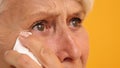 Close up of sad vulnerable old woman wiping her tears Royalty Free Stock Photo