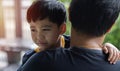 Close up sad young Asian boy crying on father hands in nature park outdoor Royalty Free Stock Photo