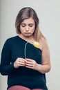 Close up Sad Young Woman Holding a Dead Rose Flower While Looking at the Camera Royalty Free Stock Photo