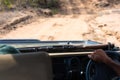 Safari guide driving with his rifle in the bush of South Africa