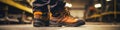 Close-up safety working shoe on a worker feet is standing at the factory, ready for working in danger workplace concept