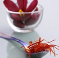 Close up of saffron on spoon with flower in glass bowl created using generative ai technology Royalty Free Stock Photo