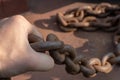 Close-up of a sailor's hand. A sailor holds a metal mooring chain in his hand. Royalty Free Stock Photo